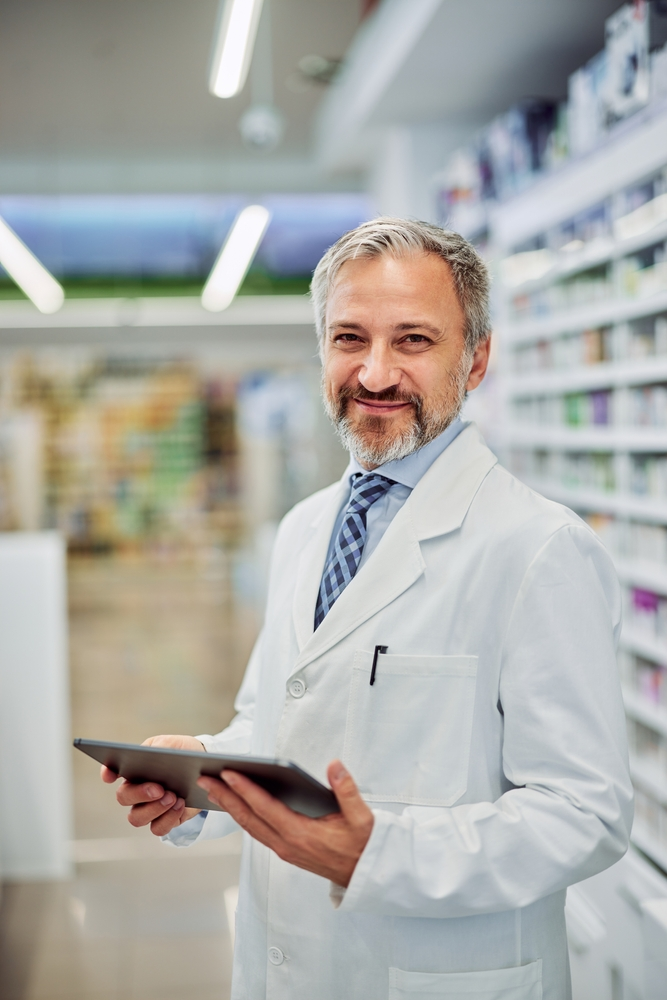 male pharmacist holding tablet