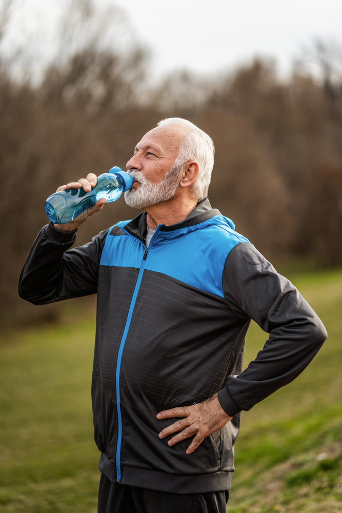 man outside drinking water